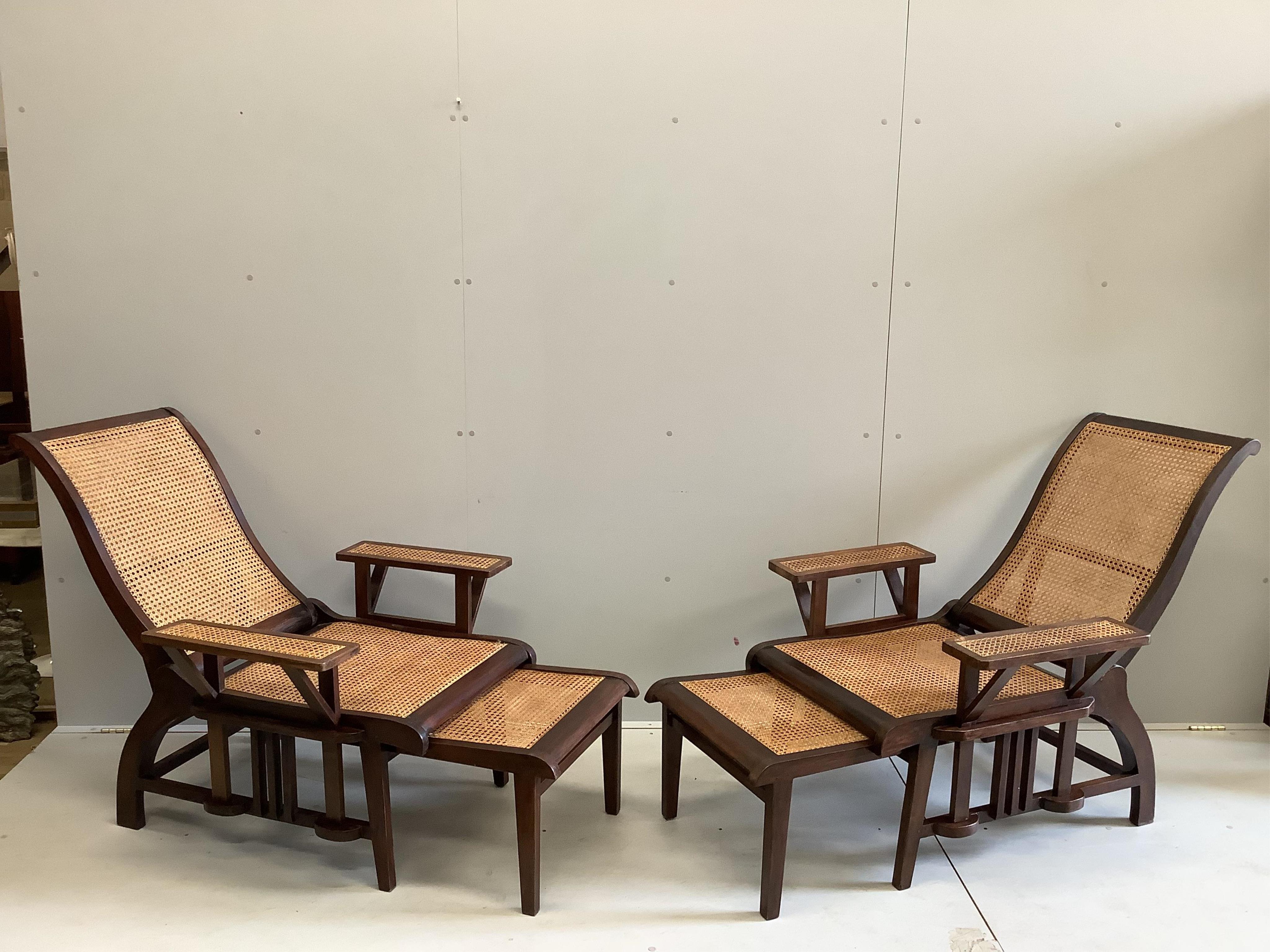 A pair of mid 20th century caned hardwood reclining garden chairs with integral sliding footrests and detachable armrests, width 85cm, depth 90cm, height 106cm. Condition - good